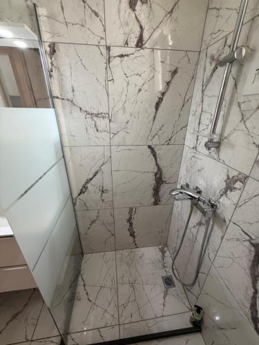 a bathroom with a shower with a glass door at Above Apartments near the Airport in Artemida