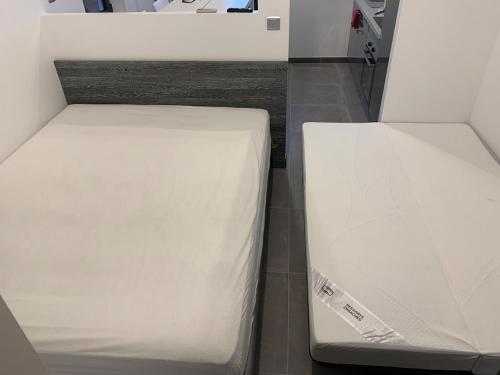 two beds in a room with white sheets at DIGITONE By GATES in Marignane