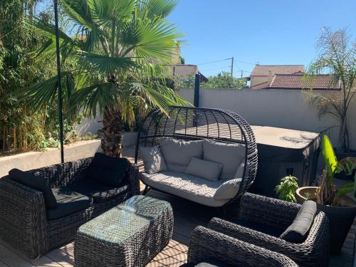 a patio with chairs and a wicker chair and a couch at DIGITONE By GATES in Marignane