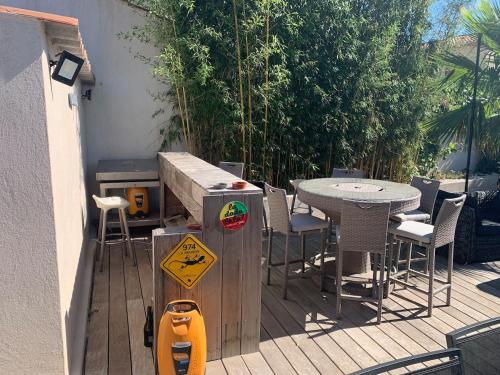 a wooden deck with a table and a table and chairs at DIGITONE By GATES in Marignane