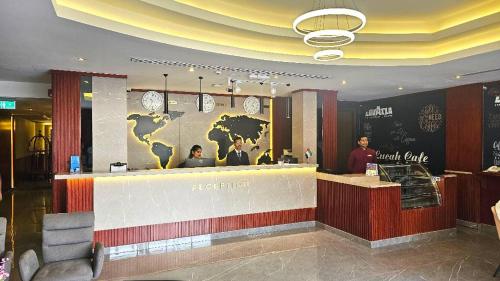 a hotel lobby with a bar with clocks on the wall at Concorde Inn Hotel in Dubai