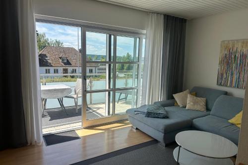 a living room with a couch and a large window at Haus Seeblick mit PKW-Stellplatz am Haus in Überlingen