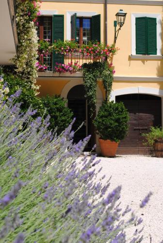 a building with purple flowers and a balcony with green shutters at B&B Casa Zia Cianetta Residenza di Campagna in Capodacqua di Foligno