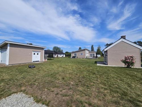 a yard with a house and a garage at Trevlig fritidshus på Norra Öland in Löttorp