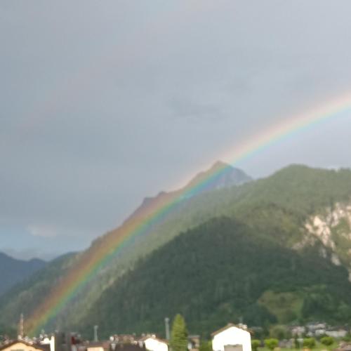 a rainbow over a mountain with a city at Casa Noemi Imer in Imer
