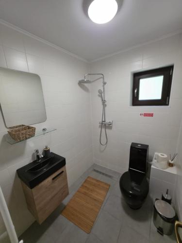 ein Badezimmer mit schwarzer Toilette und Waschbecken in der Unterkunft Evernest Guesthouse in Arefu