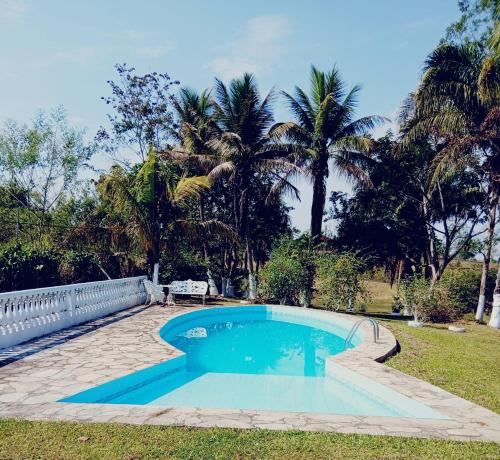 a swimming pool in a yard with palm trees at Chácara maria bonita in Rio Branco