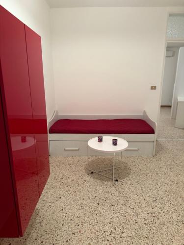 a small white table in a room with a bench at Bella Trinacria in Aragona