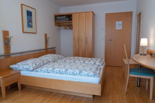 a bedroom with a bed and a table and a desk at Gästehaus Eisenerz in Eisenerz