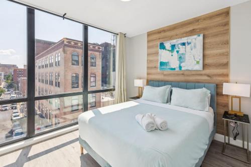a bedroom with a large bed with two towels on it at Stay at Luna on N 11th St in Philadelphia