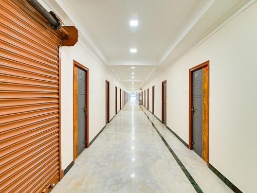 a corridor in a building with wooden doors at Hotel O Rj Royal Inn in Vellore
