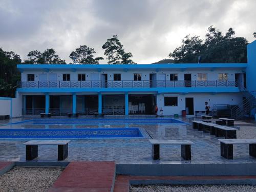 a building with a pool and benches in front of it at Paraíso Vacacional FERNANDO in Polo