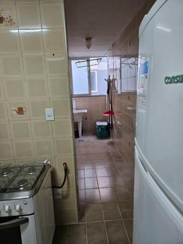 a kitchen with a stove and a refrigerator in it at Apartamento Condominio Versalles - Cabo Frio - 3 minutos da Praia do Forte in Cabo Frio