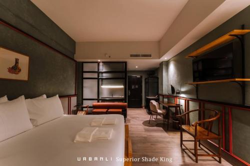 a hotel room with a bed and a table and chairs at Urbanli Hatyai Hotel in Hat Yai