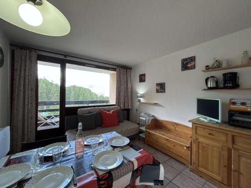 un salon avec un canapé et une table dans l'établissement Appartement Montgenèvre 6 pers, skis aux pieds, animaux acceptés, parking - FR-1-330D-70, à Montgenèvre