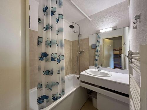 une salle de bain avec un lavabo et un rideau de douche dans l'établissement Appartement Montgenèvre 6 pers, skis aux pieds, animaux acceptés, parking - FR-1-330D-70, à Montgenèvre