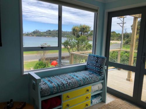 a window seat in a room with a view of the ocean at Butterfield Beach House Stewart Island incl car in Oban