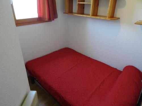 un petit banc rouge dans un coin de pièce dans l'établissement Studio cabine à Vallandry, 22m², 4 pers, proche pistes et commerces - FR-1-411-940, à Landry