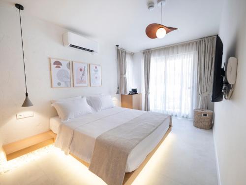a bedroom with a large bed and a television at Kai Beach Otel in Datca