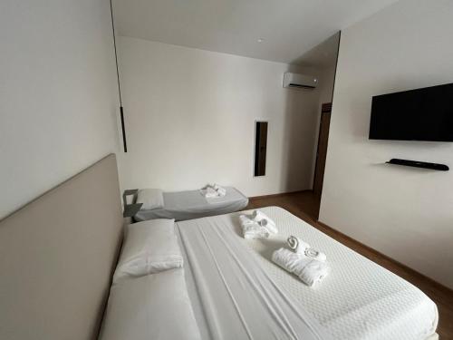 a bedroom with two beds and a flat screen tv at La Terrazza in centro in Marsala