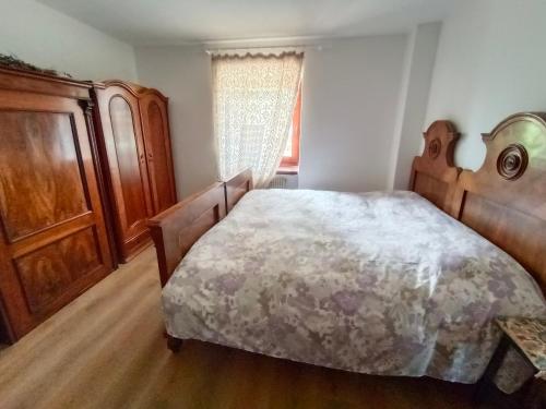 a bedroom with a large bed and a wooden cabinet at Stella Alpina in Romeno