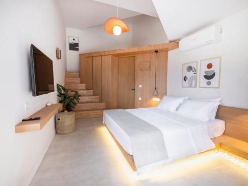 a bedroom with a white bed and a staircase at Kai Beach Otel in Datca