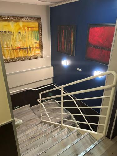 a staircase in a room with paintings on the wall at Hotel Aero Sleep Campinas in Campinas