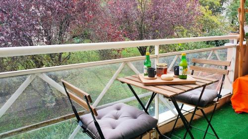 a table and two chairs on a balcony with drinks at Le cosy avec climatisation, terrasse et parking privatif in Annemasse