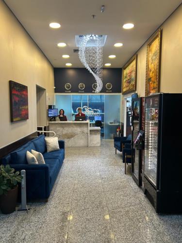 a lobby with a blue couch in a waiting room at Hotel Aero Sleep Campinas in Campinas