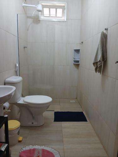 a bathroom with a toilet and a sink at Chácara da Madrinha in Guarapari