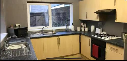 a kitchen with a sink and a stove and a window at 284 - Room 3 - Beachfront in Swansea