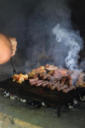 a person cooking meat on a grill with smoke at Kuća za odmor vila Ružica in Orahovica