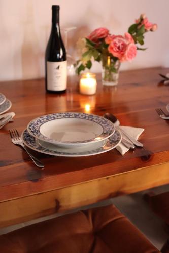 a table with a plate and a bottle of wine at Kuća za odmor vila Ružica in Orahovica