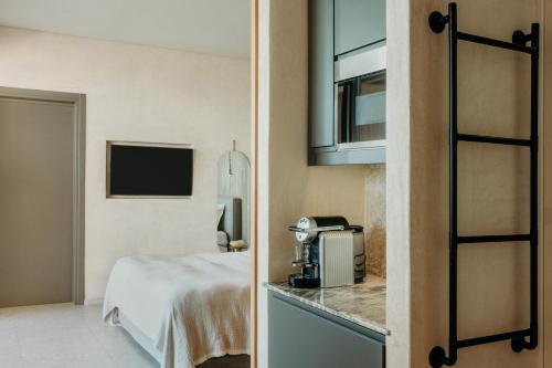 a hotel room with a bed and a microwave at Santorini Sky, Luxury Resort in Pirgos