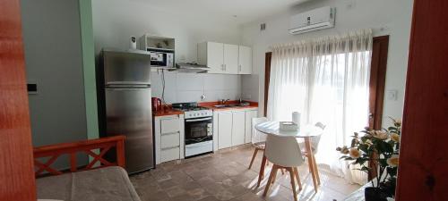 a kitchen with a stainless steel refrigerator and a table at Depto Centrico con COCHERA in Trenque Lauquen