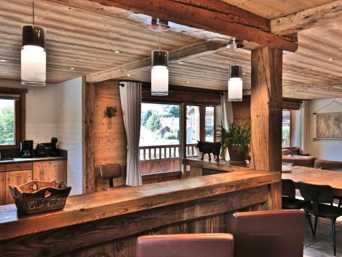 - une salle à manger avec des murs en bois, une table et des chaises dans l'établissement Superbe 5 pièces rénové avec sauna, hammam, jacuzzi, proche télécabines et village, idéal 12/14 pers. - FR-1-458-101, au Grand-Bornand