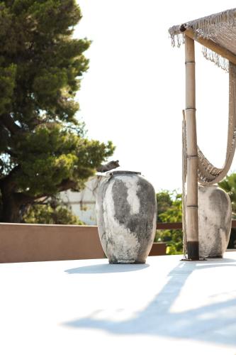 a bird sitting in a vase on a patio at Hotel Platinium Dhermi in Vlorë