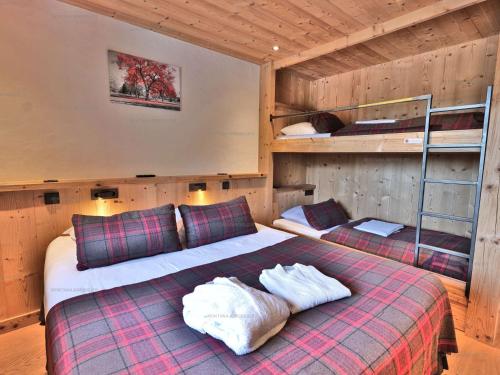 ein Schlafzimmer mit einem Bett und zwei Etagenbetten in der Unterkunft Superbe 5 pièces rénové avec sauna, hammam, jacuzzi, proche télécabines et village, idéal 12/14 pers. - FR-1-458-101 in Le Grand-Bornand
