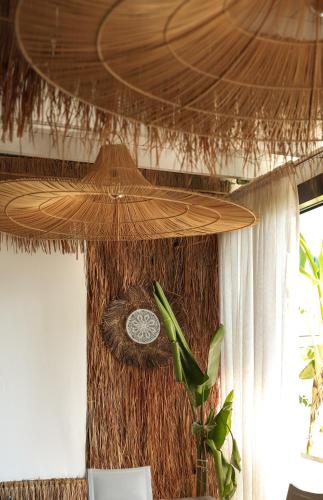 a straw ceiling with a clock in a room at Hotel Platinium Dhermi in Vlorë