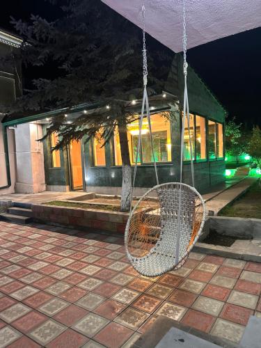 a rattan swing in front of a building at night at Private house, Own and magnificent villa, Apartments in Yerevan
