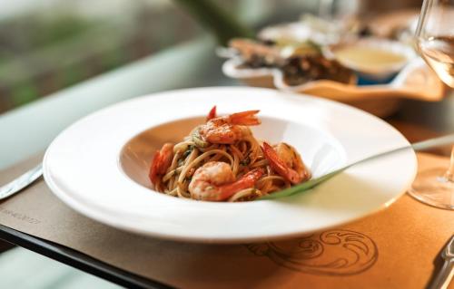 a plate of pasta with shrimp on a table at Hotel Platinium Dhermi in Vlorë