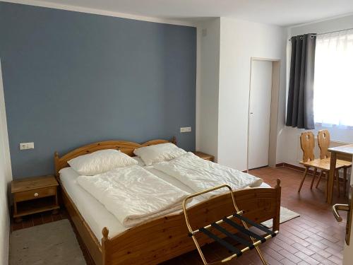 a bedroom with a wooden bed with a blue wall at Land Gut Berlinchen in Berlinchen