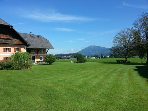 a large grass field with a house in the background at Reschbergerhof Appartements by Geierspichler in Anif