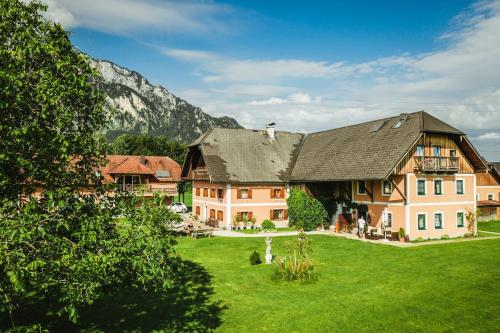 a large house with a green lawn in front of a mountain at Reschbergerhof Appartements by Geierspichler in Anif
