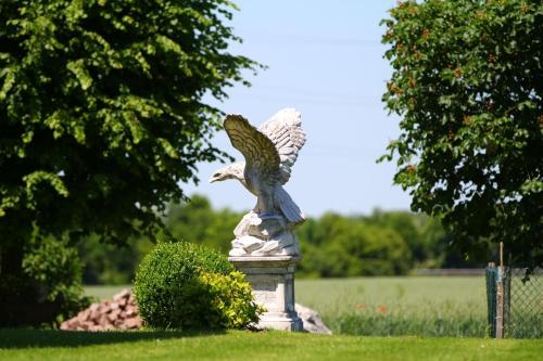 a statue of an eagle sitting in the grass at Reschbergerhof Appartements by Geierspichler in Anif
