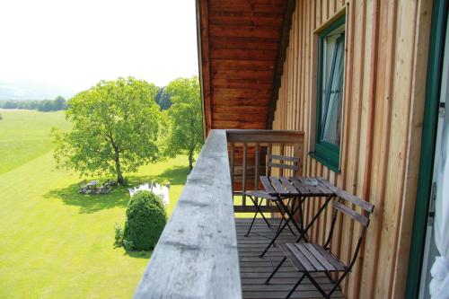 a balcony with two chairs and a table on a house at Reschbergerhof Appartements by Geierspichler in Anif