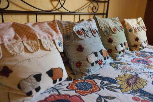 a bed with pillows on it with a floral blanket at La casa Arancione in Boves