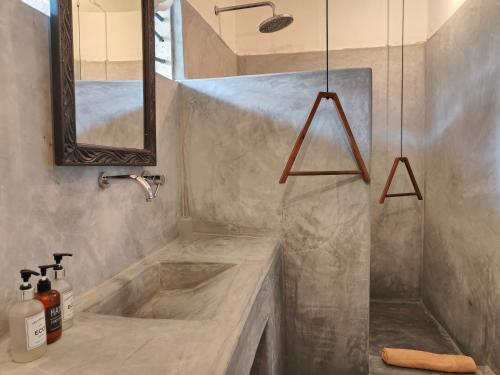 a bathroom with a sink and a mirror at Paje By Night Bungalows in Paje