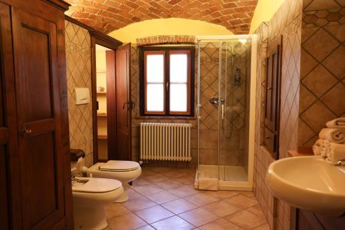 a bathroom with two toilets and a shower and a sink at La casa Arancione in Boves