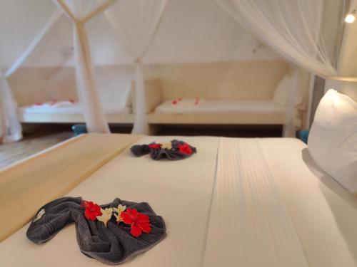 two towels on a bed in a tent at Paje By Night Bungalows in Paje